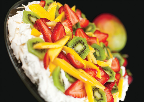 Pavlova with strawberries, kiwi fruit, and mango